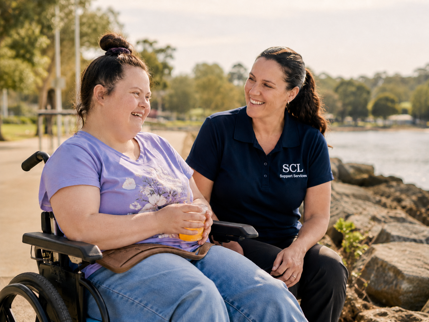 An SCL Support Services worker spending time outdoors with a participant using a wheelchair